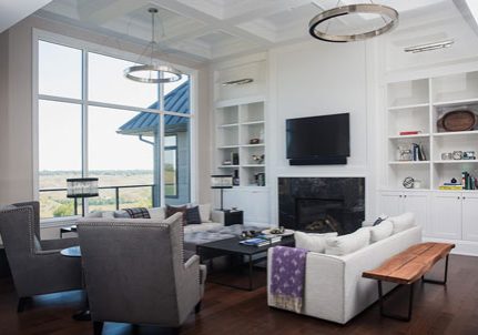 optlachancelivingwithsmallbeams Modern living room with large windows, stylish furniture, and a fireplace, showcasing a blend of comfort and contemporary design, reflecting Sila Developments LTD.'s focus on personalized renovations and new builds.